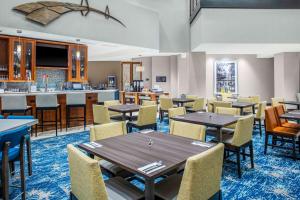 a dining room with tables and chairs and a bar at Hilton Garden Inn Charleston / Mt. Pleasant in Charleston