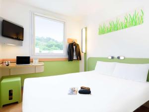 ein Schlafzimmer mit einem weißen Bett und einem Fenster in der Unterkunft Ibis Budget Bilbao Arrigorriaga in Arrigorriaga