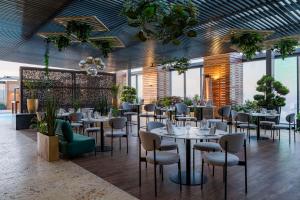 un restaurante con mesas, sillas y ventanas en Hilton Mexico City Santa Fe, en Ciudad de México