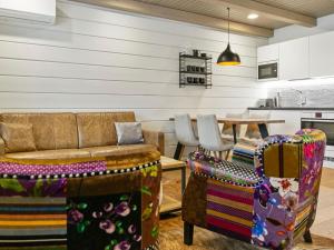 ein Wohnzimmer mit einem Sofa, Stühlen und einem Tisch in der Unterkunft Holiday Home Naava chalet 102 by Interhome in Ähtäri