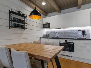 cocina con mesa de madera y sillas en Holiday Home Naava chalet 102 by Interhome en Ähtäri