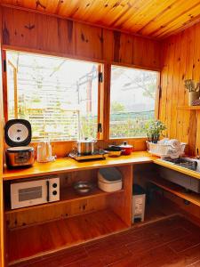 eine Küche mit einer Theke mit einer Mikrowelle und einem Fenster in der Unterkunft Lam Vien Garden Villa - Homestay Da Lat in Da Lat