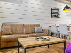 a living room with a couch and a table at Holiday Home Naava chalet 104 by Interhome in Ähtäri +10 photos