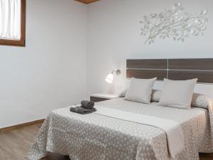 - une chambre avec 2 lits avec des draps blancs et une table dans l'établissement Holiday Home Mamasica by Interhome, à Ingenio