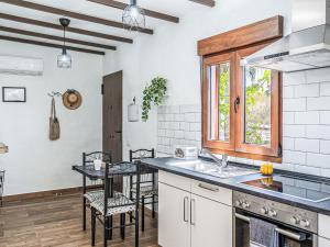 a kitchen with a sink and a table with chairs at Holiday Home Mamasica by Interhome in Ingenio