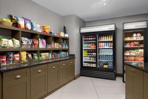 a store aisle with a refrigerator and shelves with food at Homewood Suites by Hilton Reading-Wyomissing in Wyomissing