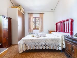a bedroom with a large bed with a red headboard at Holiday Home D'estiu by Interhome in El Grao