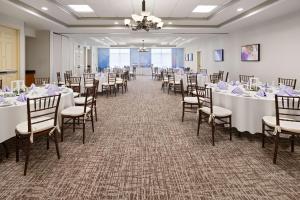 un salón de banquetes con mesas y sillas blancas en Hilton Garden Inn Milford, en Milford