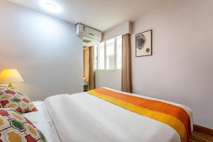 a bedroom with a bed with a rainbow blanket at Xi'an See Tang Guesthouse in Xi'an