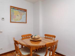 - une table à manger avec des chaises et une carte murale dans l'établissement Apartment Marina by Interhome, à Cambrils
