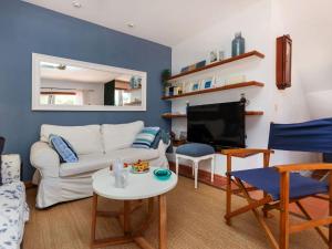 een woonkamer met een witte bank en een tv bij Holiday Home Vayreda by Interhome in Begur