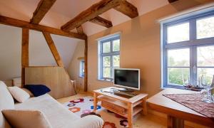 a living room with a white couch and a tv at Haus zu den Büschen 04 in Wustrow +13 photos