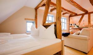 a bedroom with two white beds and a couch at Haus zu den Büschen 04 in Wustrow
