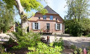 a brick house with a tree in front of it at Haus zu den Büschen 04 in Wustrow