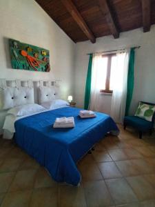 a bedroom with a blue bed with a blue blanket at Il Miraggio Tanca Piras in Nebida