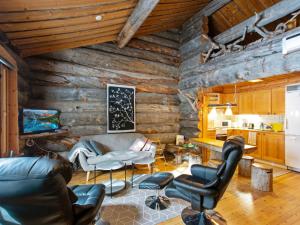 un soggiorno con pareti in legno e sedie in pelle di Holiday Home Luostonsokka 1 by Interhome a Luosto
