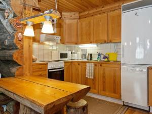 una cucina con armadi in legno e tavolo in legno di Holiday Home Luostonsokka 1 by Interhome a Luosto