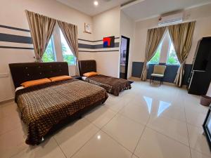 a bedroom with two beds and a television in it at The Blue Guest House, Parking, Aulong in Taiping