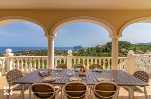 - une table sur un balcon avec vue sur l'océan dans l'établissement Villa Treveris by Abahana Villas, à Teulada