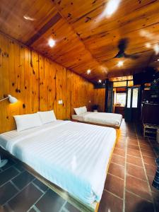 a bedroom with two beds in a wooden wall at Lam Vien Garden Villa - Homestay Da Lat in Da Lat