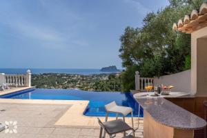Cette villa dispose d'une piscine avec une table et des chaises. dans l'établissement Villa Treveris by Abahana Villas, à Teulada