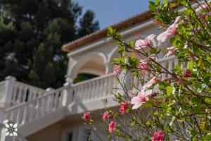 une maison blanche avec un balcon et des fleurs roses dans l'établissement Villa Treveris by Abahana Villas, à Teulada