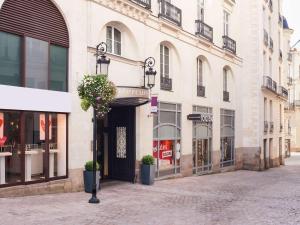 un bâtiment avec un panneau sur le côté d'une rue dans l'établissement Mercure Nantes Centre Passage Pommeraye, à Nantes