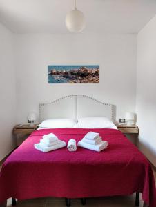 カステッランマーレ・デル・ゴルフォにあるAppartamenti Blu Mareのベッドルーム1室(赤いベッド1台、タオル付)