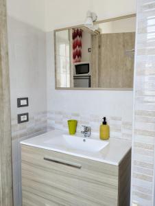 bagno con lavandino e specchio di Appartamenti Blu Mare a Castellammare del Golfo