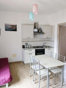 Una cocina con una mesa y sillas en una habitación. en Appartamenti Blu Mare, en Castellammare del Golfo