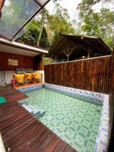 a swimming pool with a fence and a wooden deck at Penginapan segitiga pangalengan in Riunggunung