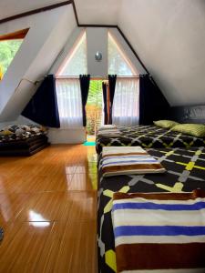 two beds in a room with a attic at Penginapan segitiga pangalengan in Riunggunung