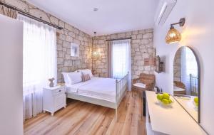 a bedroom with a bed and a stone wall at Caliza Alaçatı in Alaçatı