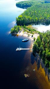 an island with two boats in the water at Saimaa Experience in Savonlinna