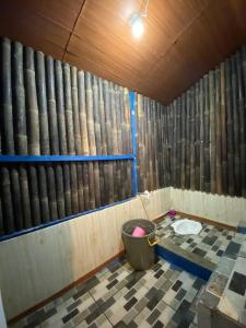 Habitación con aseo y pared de barriles de madera. en Penginapan segitiga pangalengan, en Riunggunung
