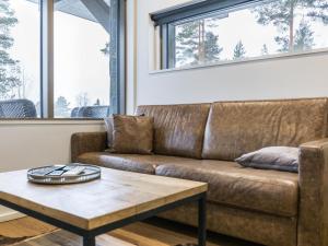 brązowa skórzana kanapa w salonie ze stolikiem kawowym w obiekcie Holiday Home Naava chalet 101 by Interhome w mieście Ähtäri