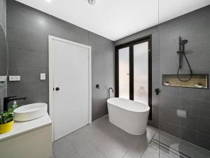 a bathroom with a white tub and a sink at Central 3BR & Central station&Chinatown-5 mins walk in Sydney +10 photos