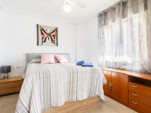 een slaapkamer met een bed met roze kussens erop bij Apartment Vistamar II - Marina d'Or by Interhome in Oropesa del Mar
