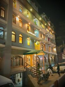 a large building with people standing outside of it at night at The Avenue River Side Hotel - Near Volvo Bus Stand Manali in Manāli
