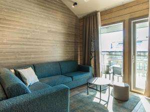 ein Wohnzimmer mit einem blauen Sofa und einem Tisch in der Unterkunft Holiday Home Uniikki 75- c402 by Interhome in Pyhätunturi