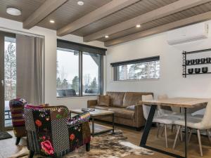 a living room with a couch and a table at Holiday Home Naava chalet 105 by Interhome in Ähtäri