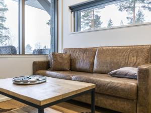 a brown leather couch in a living room with a coffee table at Holiday Home Naava chalet 105 by Interhome in Ähtäri