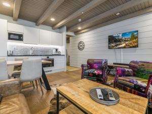 a living room with a table and chairs and a kitchen at Holiday Home Naava chalet 105 by Interhome in Ähtäri