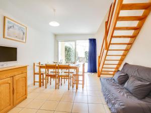 a living room with a dining room table and a staircase at Holiday Home Les hameaux de l'Océan by Interhome in Maubuisson
