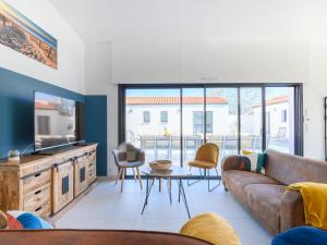 a living room with a couch and a tv at Villa Charme de la Blancharderie by Interhome in Barbâtre