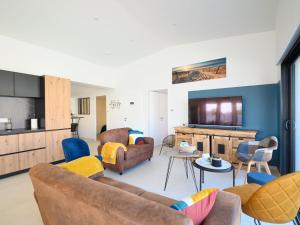 a living room with a couch and a tv at Villa Charme de la Blancharderie by Interhome in Barbâtre