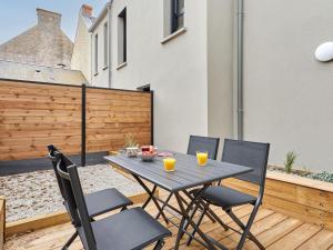a patio with a table and chairs on a deck at Holiday Home Le Sund by Interhome in Regnéville-sur-Mer