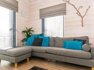 ein Wohnzimmer mit Sofa und blauen Kissen in der Unterkunft Holiday Home Golfarinkunnas 7b by Interhome in Jämsä