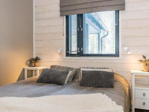 ein Schlafzimmer mit einem Bett mit zwei Kissen und einem Fenster in der Unterkunft Holiday Home Golfarinkunnas 7b by Interhome in Jämsä