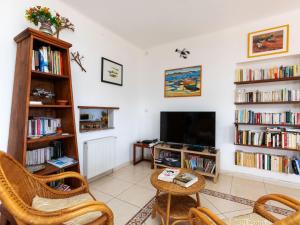 ein Wohnzimmer mit einem TV und Bücherregalen in der Unterkunft Holiday Home TORTUGA by Interhome in Llança